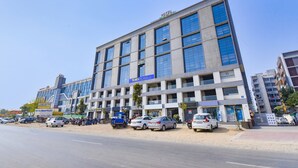 A modern hotel building with multiple floors, large windows, and a prominent sign indicating it is a hotel. - Fabhotel Maan Palace (Ahmedabad)