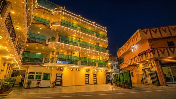 A multi-story hotel with balconies, a sign for 'fabHOTELS', and potted plants in the foreground. - FabHotel Surya Palace 2 (Chandigarh)