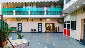 A spacious indoor area with a tiled floor, a green and white balcony, and a sign for 'fab express'. - FabHotel Surya Palace 2 (Chandigarh)