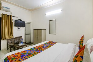 A hotel room with a bed, a television mounted on the wall, a desk with a chair, and a wardrobe. - FabHotel Surya Palace 2 (Chandigarh)