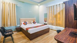 A hotel room with a bed, a desk, a chair, and curtains. - Fabhotel The Avr Grand (Lucknow)