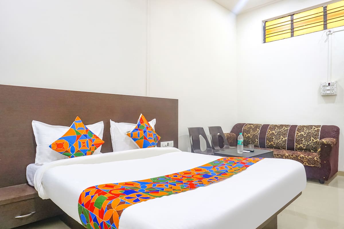 A hotel room with a large bed, a sofa, and a small table.