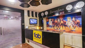 A hotel reception area with a reception desk, clocks, and a large wall mural of horses. - Fabhotel Leaf Paradise (Lucknow)