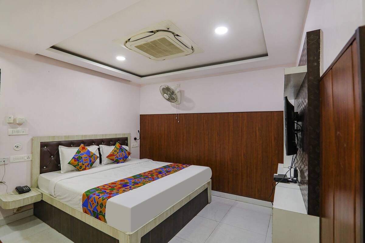 A bedroom with a bed, bedside table, and a ceiling fan.