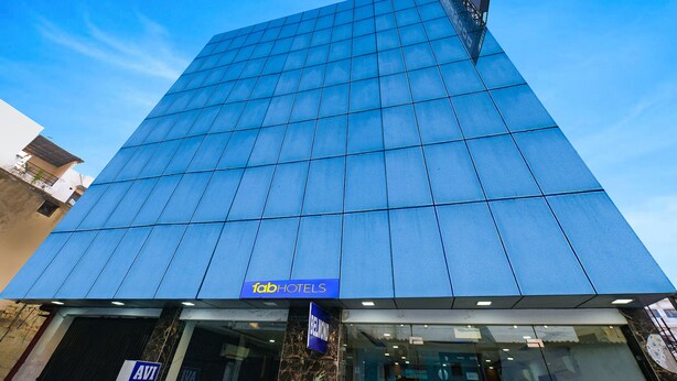 A modern hotel with a glass facade and a sign for 'Tab Hotels'. - FabHotel Belwood (New Delhi)