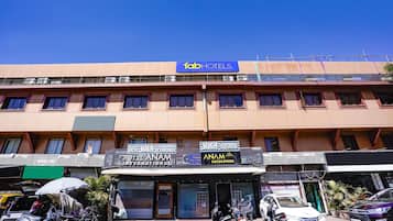 A hotel with multiple floors, a prominent 'fab hotels' sign, and several parked motorcycles and scooters in front.