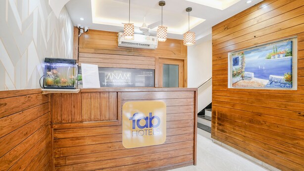 Een houten receptiebalie, een bord met 'fab hotels' en een schilderij van een kustlandschap aan de muur.