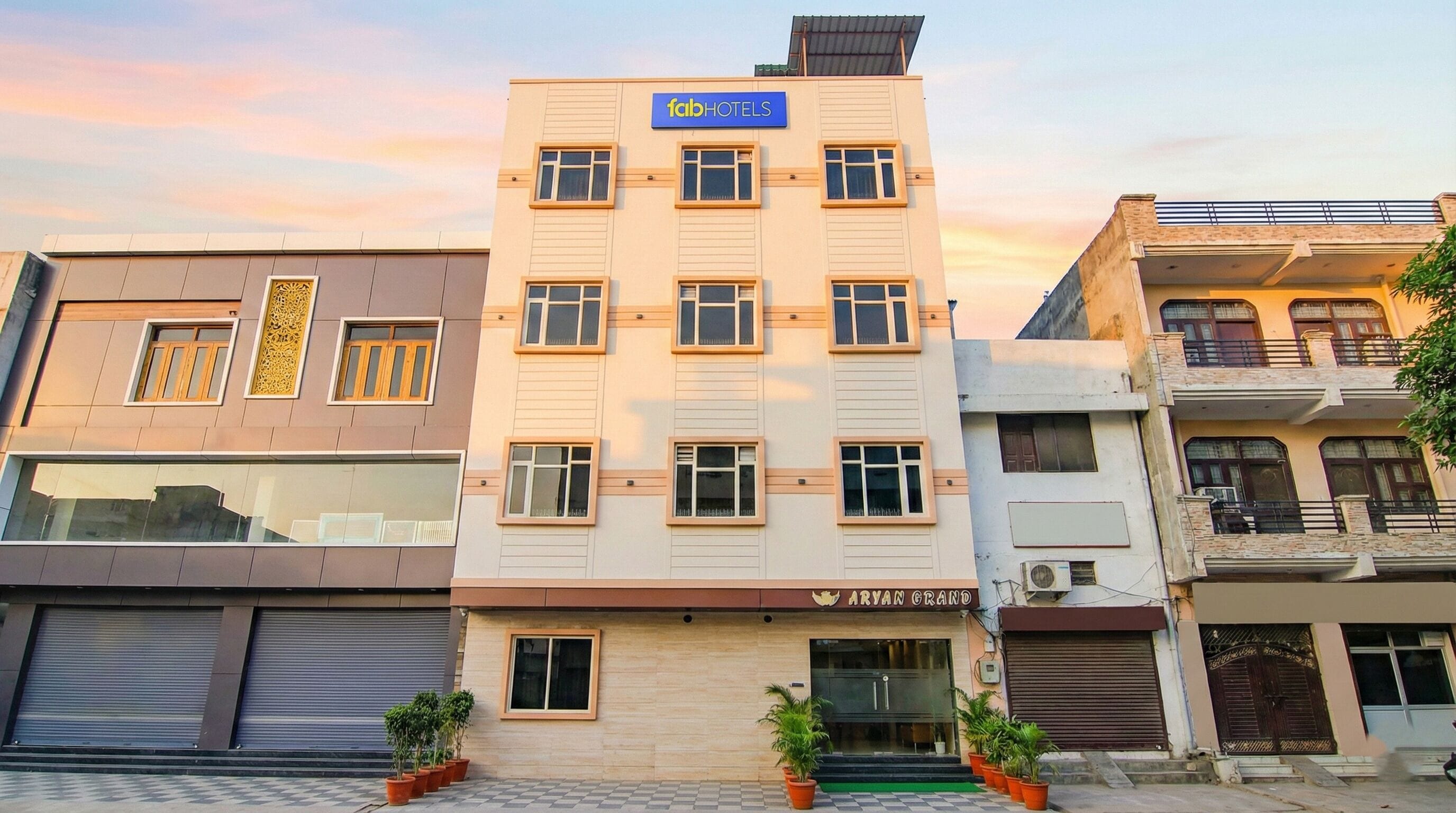 A building with a sign for 'fabHOTELS' and 'ARYAN GRAND' on the facade.