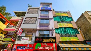 A multi-story building with various signs, including a hotel named 'Bhabai Ram' and a restaurant named 'Panchayat'. - Fabexpress Brahmasmi (Ujjain)