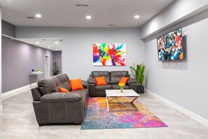 Una sala de estar moderna con un sofá modular, una mesa de centro y arte abstracto llamativo en las paredes.