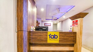 A reception desk with a wooden finish and a sign reading "fab hotels". - Fabexpress Subh Residency (Howrah)
