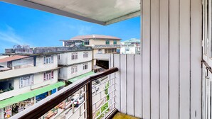 A balcony with a view of multi-story buildings and a clear blue sky. - Fabhotel Siljong (Gangtok)