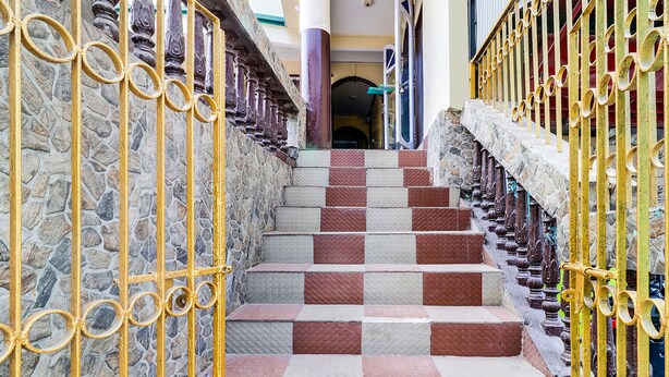 A staircase with alternating red and beige steps, flanked by stone walls and yellow metal railings. - Fabhotel Siljong (Gangtok)