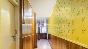 A hallway with wooden paneling and a yellow wall with cut-out patterns. - Fabhotel Siljong (Gangtok)