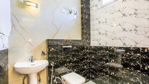 A bathroom with a white sink, a toilet, and a shower area. - Fabexpress Ashirwad Residency Arn To Gst (Mumbai)