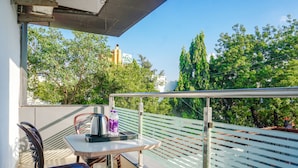 A balcony with a table, chairs, and a railing. - Fabhotel Tulsi Park (Rahata)