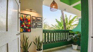 A balcony with potted plants, a green railing, and a hanging light fixture. - Via Jesant Valley Resort - Nr. Candolim Beach (Candolim)