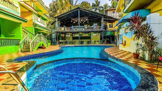 A swimming pool with a checkered border, a covered seating area, and a staircase leading to a balcony. - Via Jesant Valley Resort - Nr. Candolim Beach (Candolim)