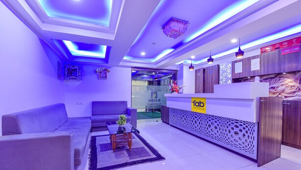 A modern hotel lobby with a reception desk, sofas, and a decorative ceiling. - Fabexpress Radhe Residency (Ahmedabad)