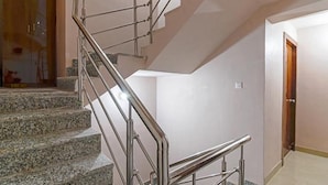 A staircase with metal railings and granite steps. - Fabexpress Golden Palace (Kolkata)