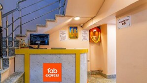 A reception desk with a 'fab express' sign, a staircase, and a 'no smoking' sign. - Fabexpress Golden Palace (Kolkata)