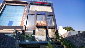 Un hotel con una moderna facciata in vetro, con un cartello ben visibile per 'JRTower Hotel Crown' e un'insegna 'Tab Hotels' sopra.