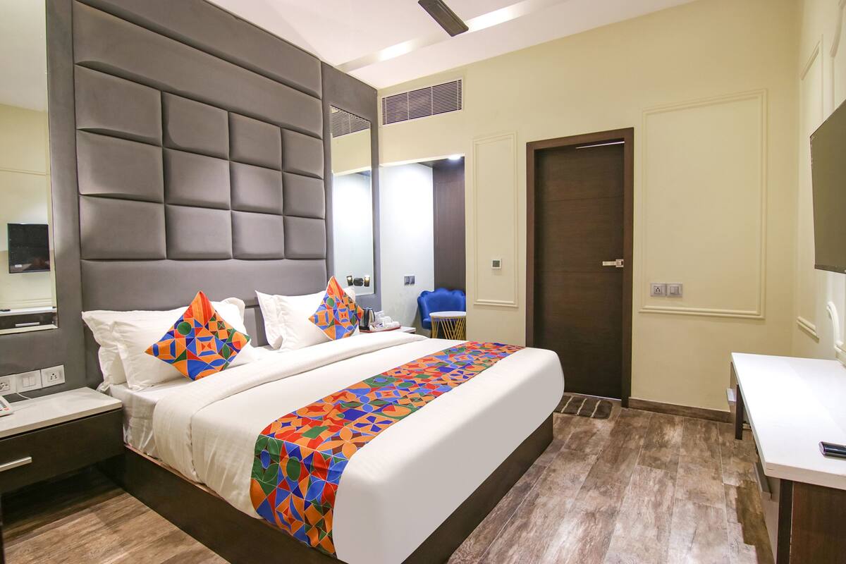 A hotel room with a large bed, a desk, and a chair.