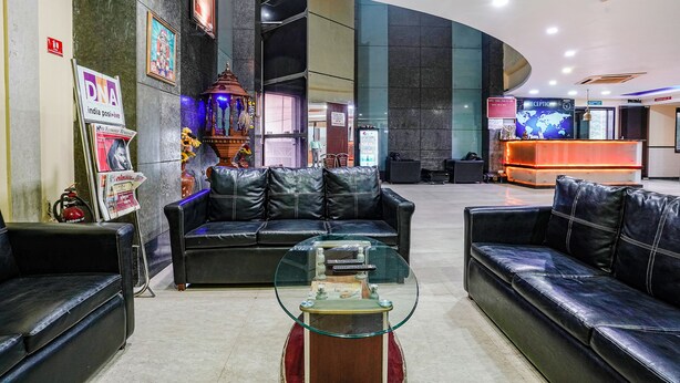 A lobby with leather sofas, a glass coffee table, and a reception desk. - Fabhotel Prime Three Star (Panvel)