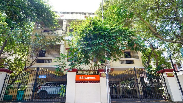 A gated entrance with a 'fabexpress' sign, a white building with balconies, and a tree in front. - Fabexpress Shree Shylee Niwas (Chennai)