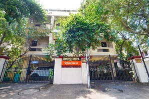 A gated entrance with a 'fabexpress' sign, a white building with balconies, and a tree in front. - Fabexpress Shree Shylee Niwas (Chennai)