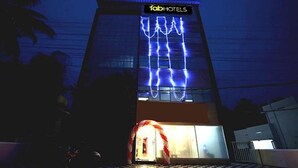 A hotel with a prominent neon sign and a large entrance arch. - Fabexpress Majestic Le Frank (Thiruvananthapuram)