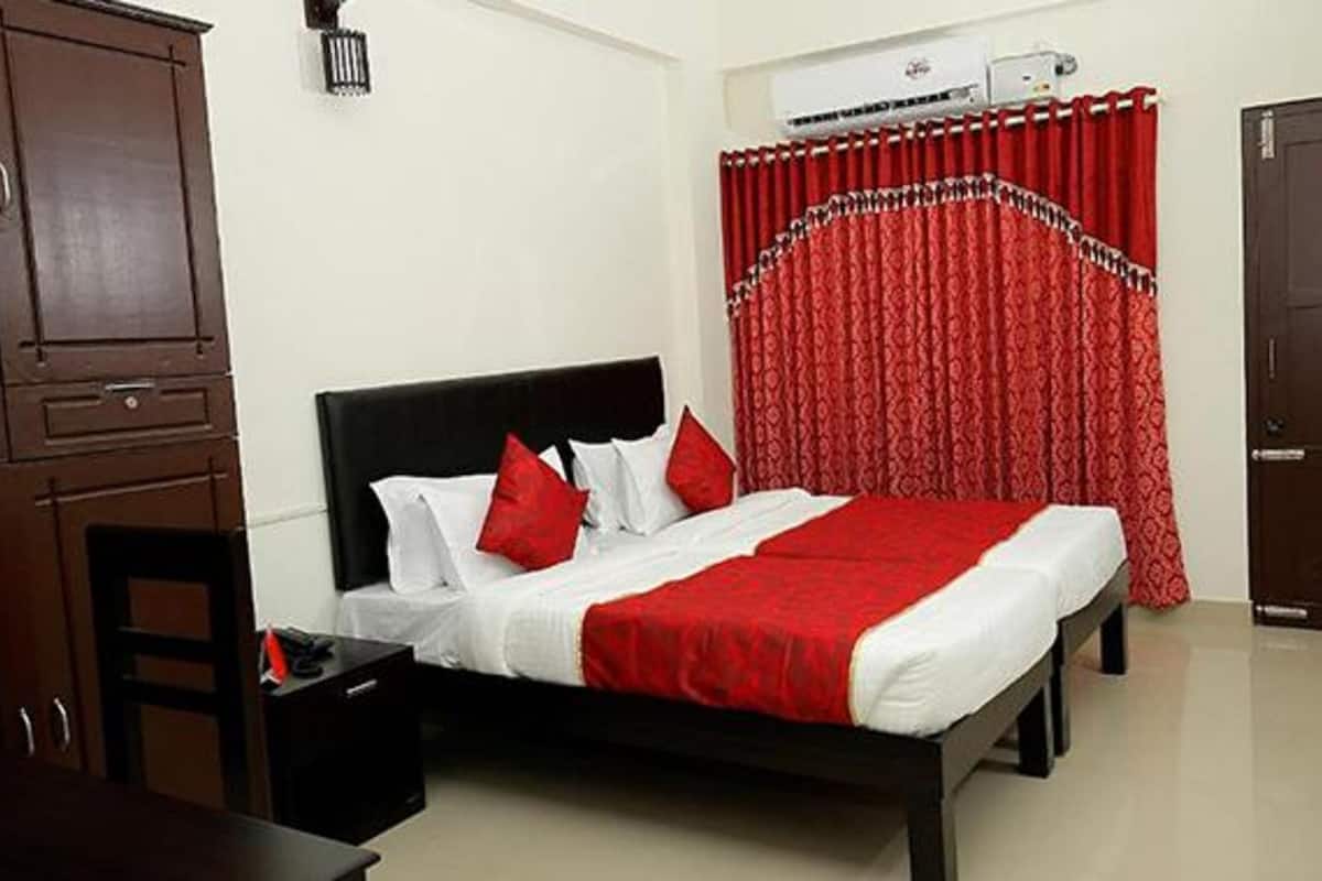 A bedroom with a bed, a desk, a wardrobe, and a door.
