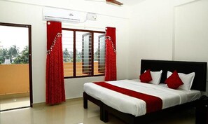 Un dormitorio con cama, cortinas rojas y ventana con vistas.