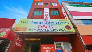 A hotel with a sign for 'The Residency Hotel' and 'Dilli 6 Restaurant & Party Hall'. - Fabexpress The Residency (Noida)