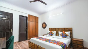 Una camera da letto con un letto in legno, una ventola a soffitto, un armadio e una sedia verde.