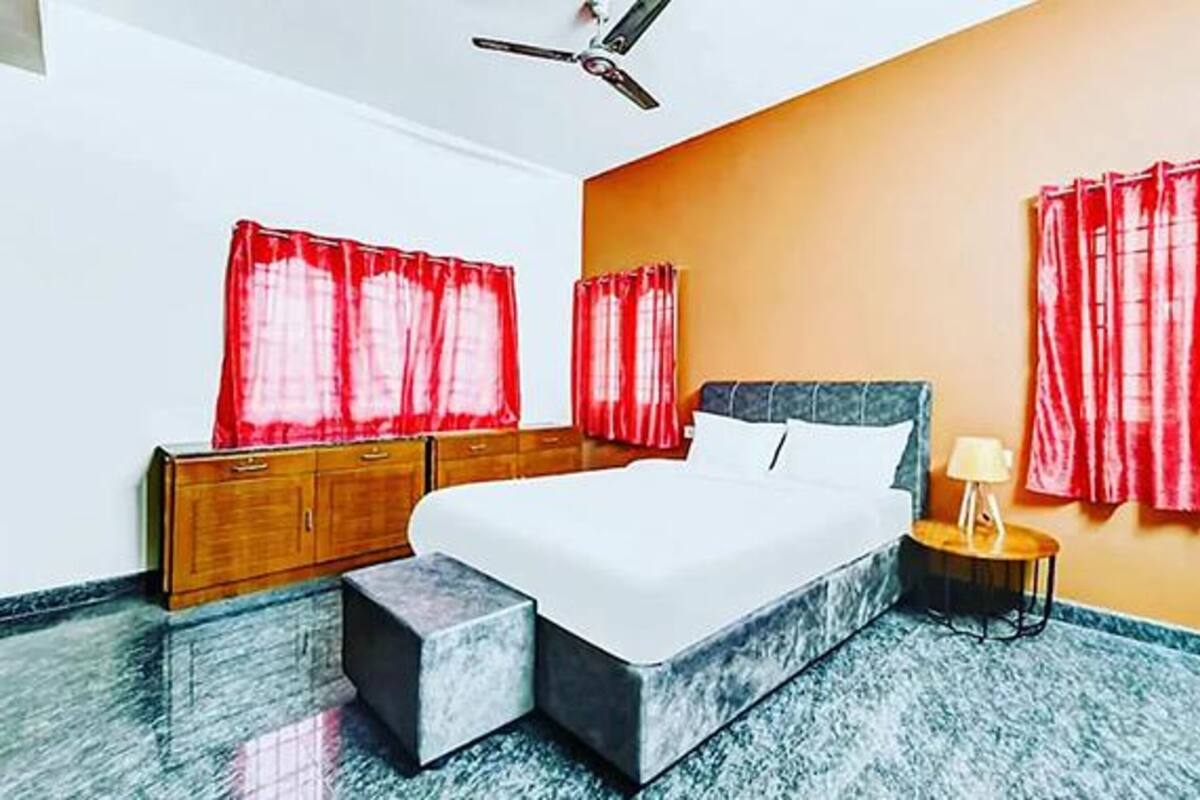 Un dormitorio con cama, armarios de madera, una mesita de noche y un ventilador de techo.