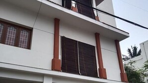 A two-story building with large windows and a balcony. - Fabexpress Aathira Inn (Chennai)