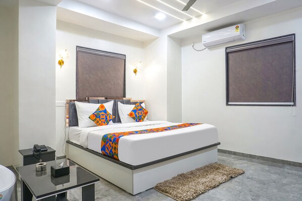 A modern hotel room with a bed, bedside table, and a small desk. - Fabhotel Hill Top Inn (Pune)