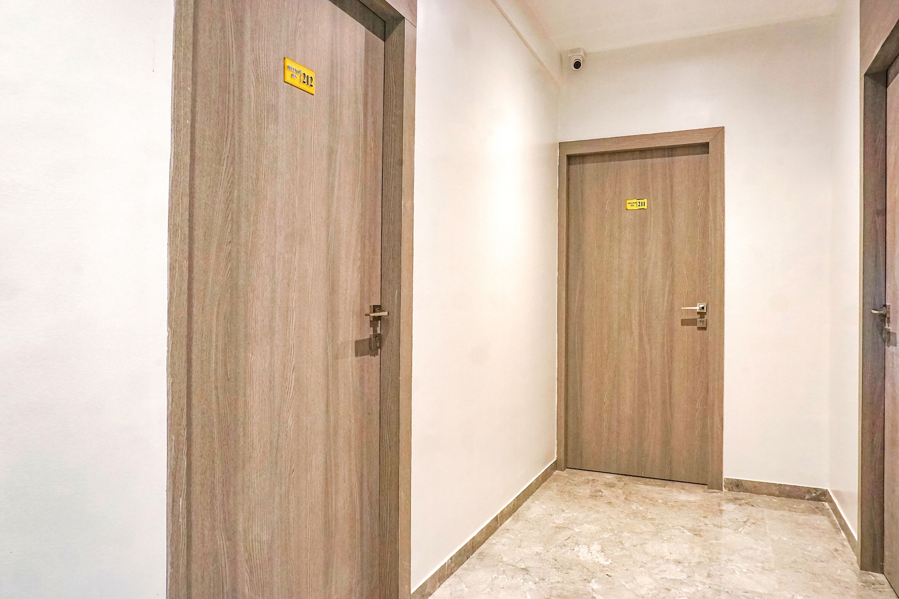 Um corredor com portas de madeira, cada uma delas numerada.