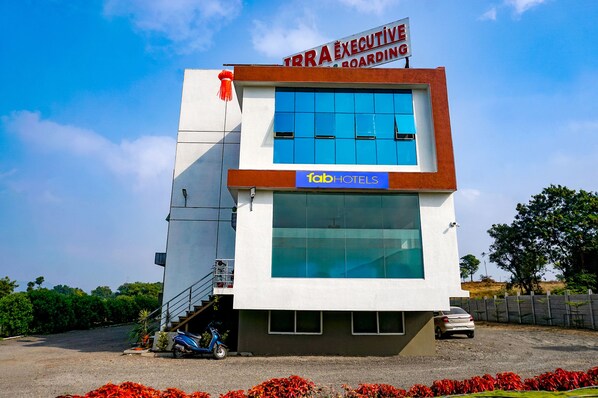 A modern building with a sign for TRRA Executive Boarding and a FABHOTELS sign. - Fabhotel Irra Executive (Sasvad)
