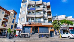 Un hôtel à plusieurs étages doté de balcons, de climatiseurs et d’une enseigne indiquant « HÔTEL BUNGALOW 18 ».