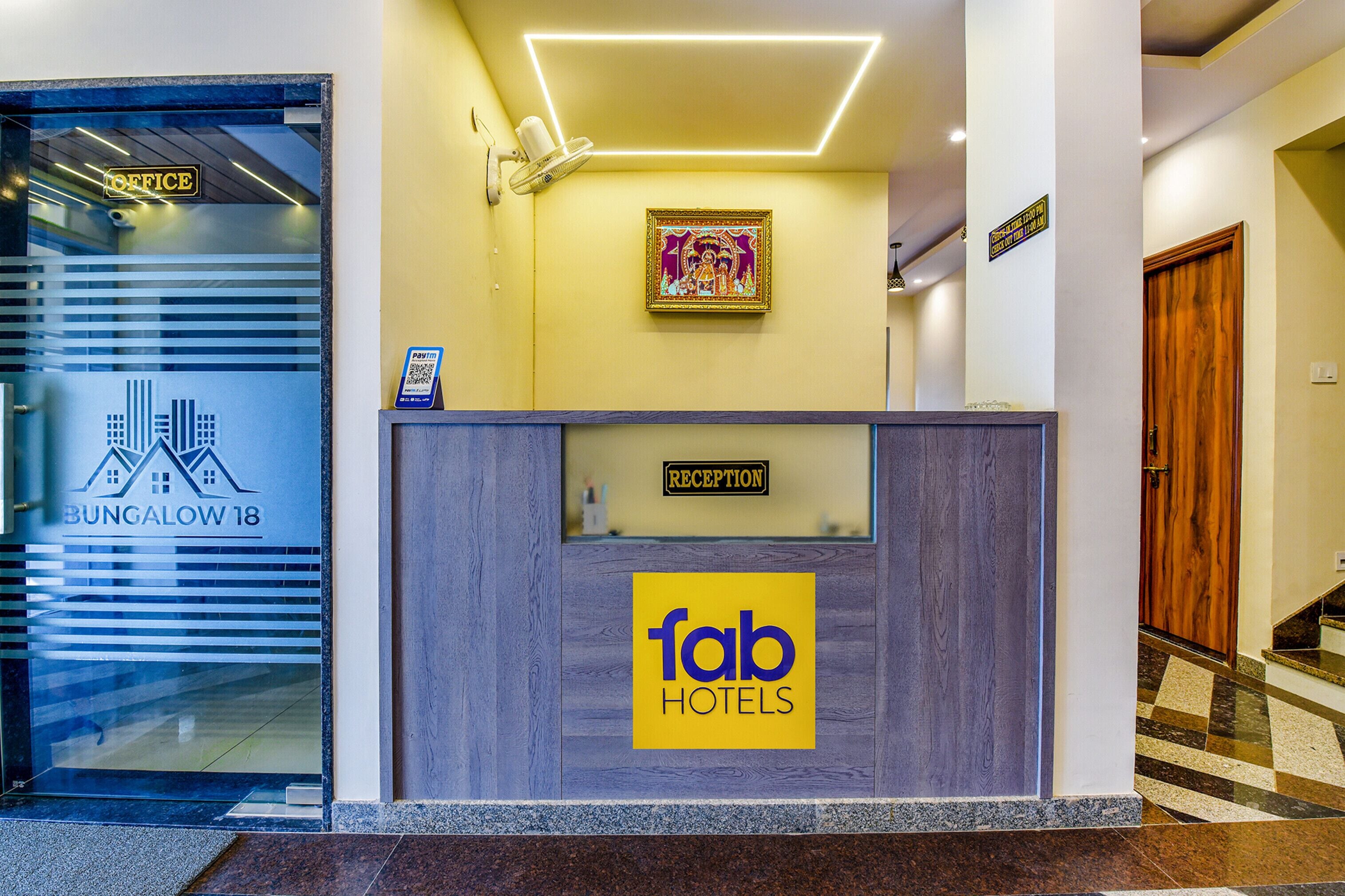 A reception desk with a 'fab hotels' sign, a 'reception' sign above it, and a framed artwork on the wall.