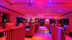 A hotel lobby with checkered sofas, a bar area, and a television screen. - Fabhotel Prime The Vijay Park Arumbakkam (Chennai)