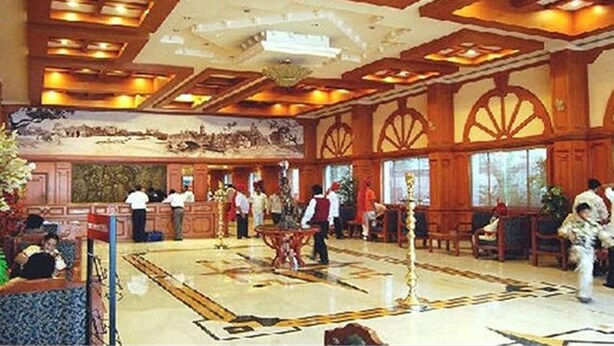 A spacious lobby with a high ceiling, ornate wood paneling, and a large mural. - Fabhotel Prime The Vijay Park Arumbakkam (Chennai)