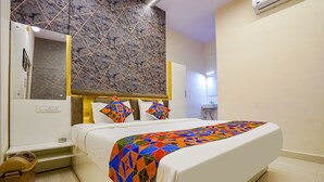 A modern hotel room with a large bed, a marble-patterned wall, and a bathroom visible in the background. - Fabhotel Olive Stay Inn (Nagpur)