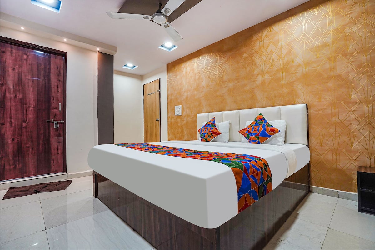 A modern bedroom with a large bed, a ceiling fan, and a wooden door.