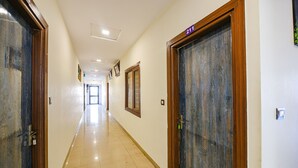 A hallway with doors labeled 203 and 211, leading to rooms. - Fabexpress Alaknanda Paradise (Dehradun)