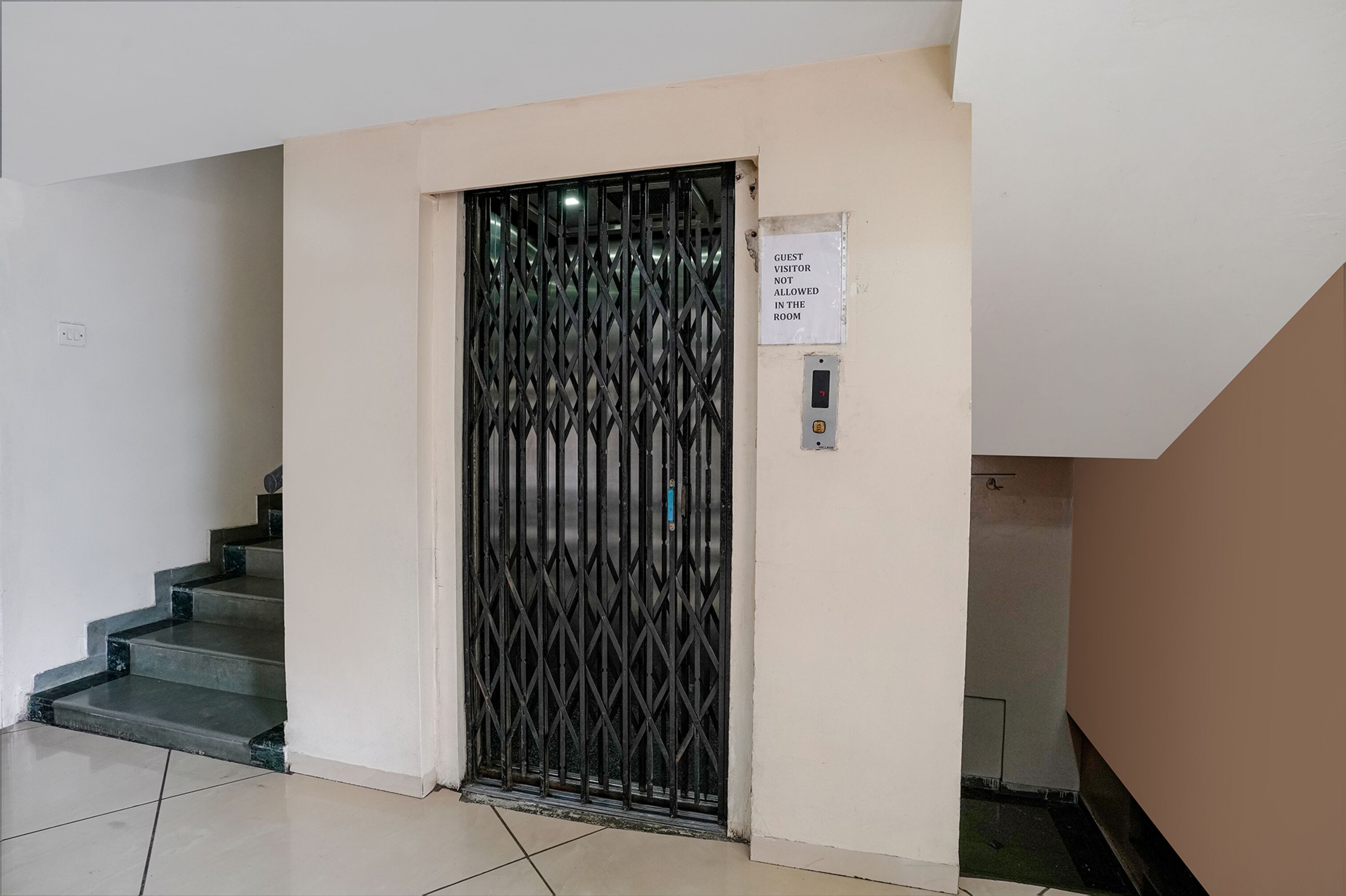 A staircase with a metal gate and a sign indicating guest visitor access.