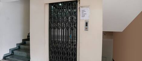 A staircase with a metal gate and a sign indicating guest visitor access.
