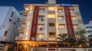 Un hotel de varios pisos con un letrero que dice "fabHOTELS" y un letrero en un idioma local.